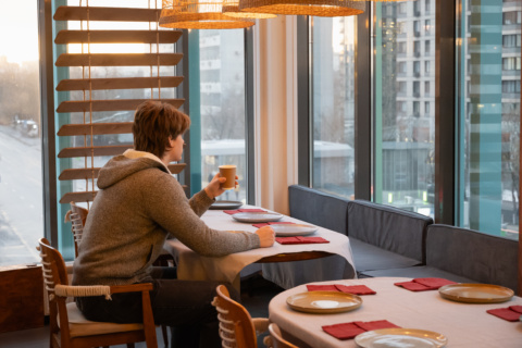 Person enjoying coffee by window.